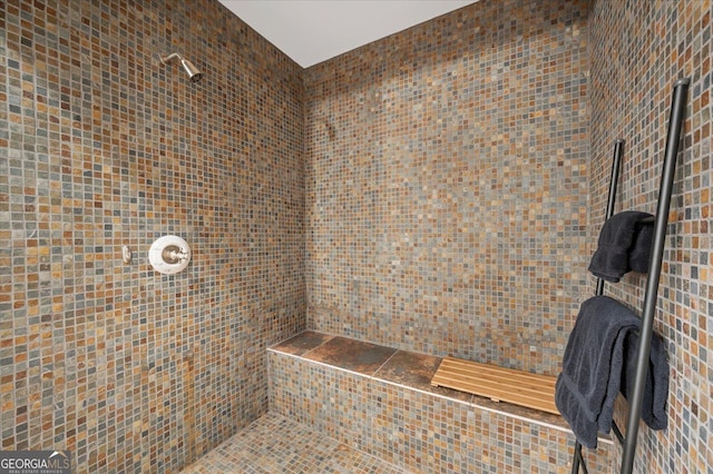 bathroom featuring tiled shower and tile walls