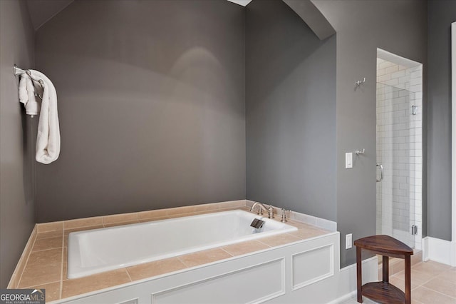 bathroom with a stall shower and a garden tub