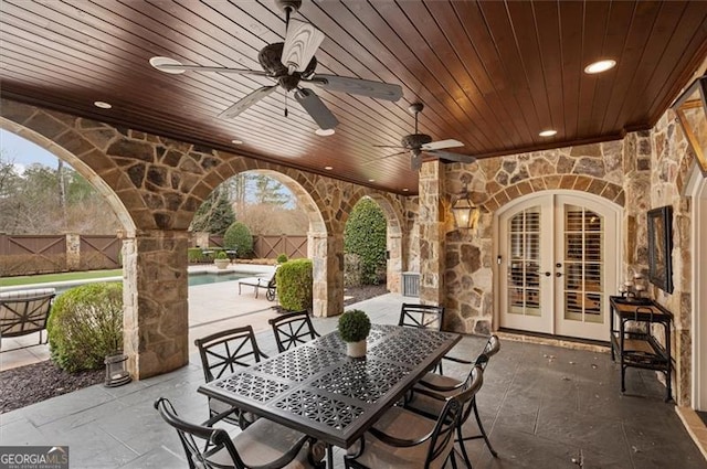 view of patio with french doors, a fenced backyard, a ceiling fan, and outdoor dining area