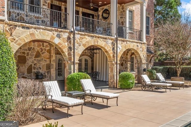 view of patio / terrace with a balcony, french doors, and a ceiling fan