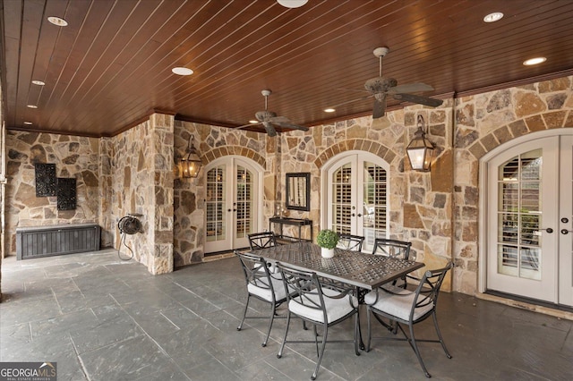 view of patio / terrace featuring ceiling fan, an outdoor stone fireplace, outdoor dining area, and french doors