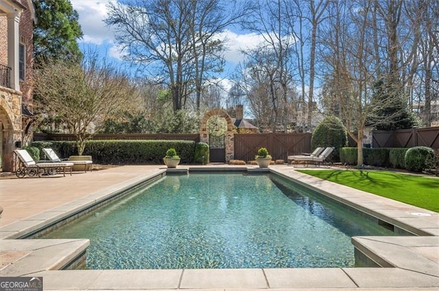view of swimming pool with a fenced backyard and a patio