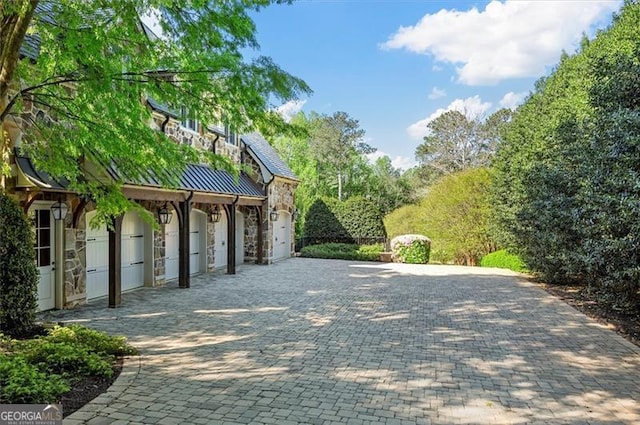view of property's community featuring decorative driveway