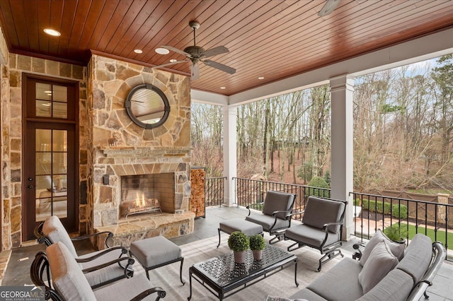 view of patio / terrace featuring ceiling fan and an outdoor living space with a fireplace