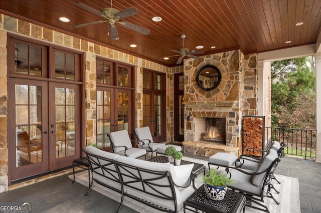 view of patio with a ceiling fan, french doors, and an outdoor living space with a fireplace