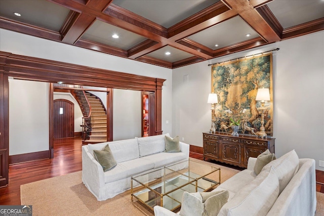 living room featuring arched walkways, coffered ceiling, wood finished floors, stairs, and beam ceiling