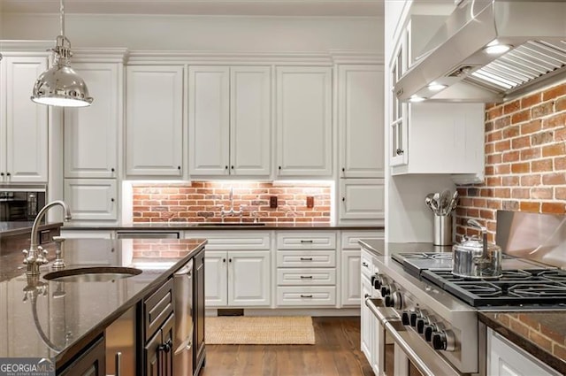 kitchen with range hood, a sink, high end range, white cabinetry, and crown molding
