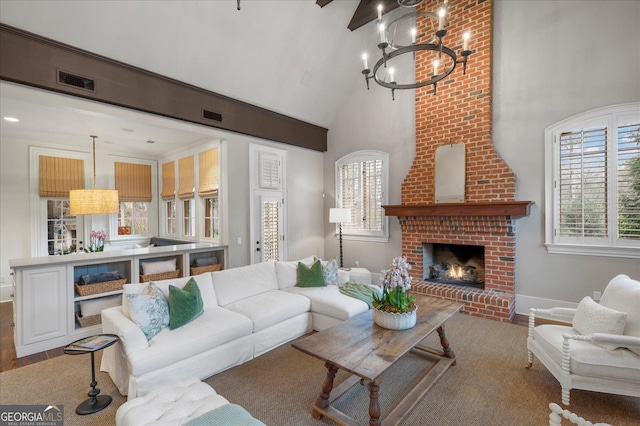 living room featuring plenty of natural light, high vaulted ceiling, a brick fireplace, and visible vents