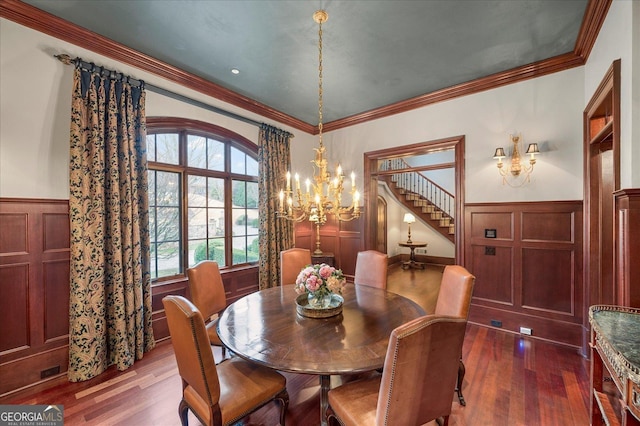 dining area with crown molding, a wainscoted wall, and dark wood finished floors