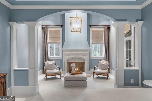 living area featuring a chandelier, carpet floors, arched walkways, and ornamental molding