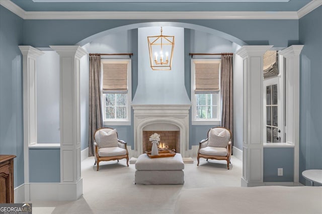 sitting room with arched walkways, carpet, crown molding, and a lit fireplace