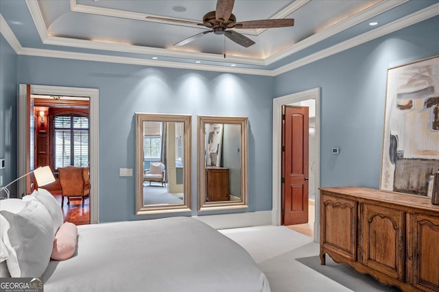 bedroom featuring ornamental molding, a raised ceiling, and a ceiling fan