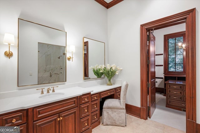 full bathroom with a marble finish shower, vanity, and baseboards