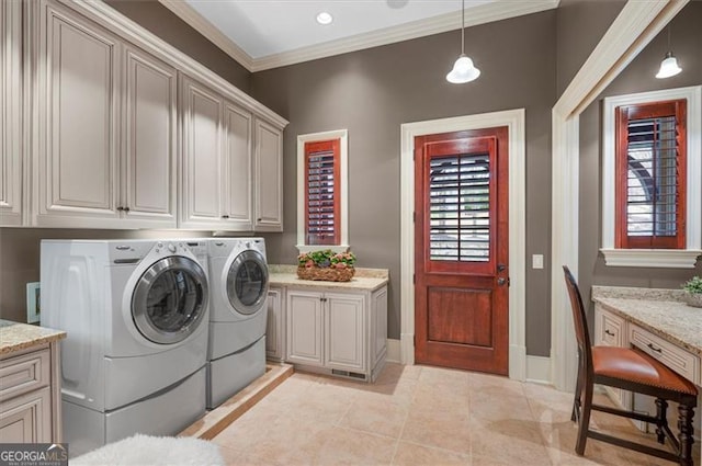 washroom with cabinet space, washer and clothes dryer, light tile patterned flooring, ornamental molding, and baseboards