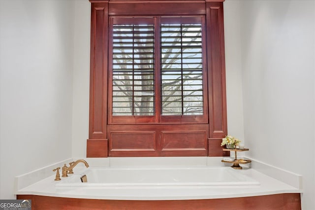 bathroom with plenty of natural light and a bath