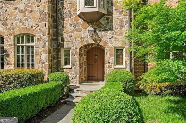 doorway to property with stone siding