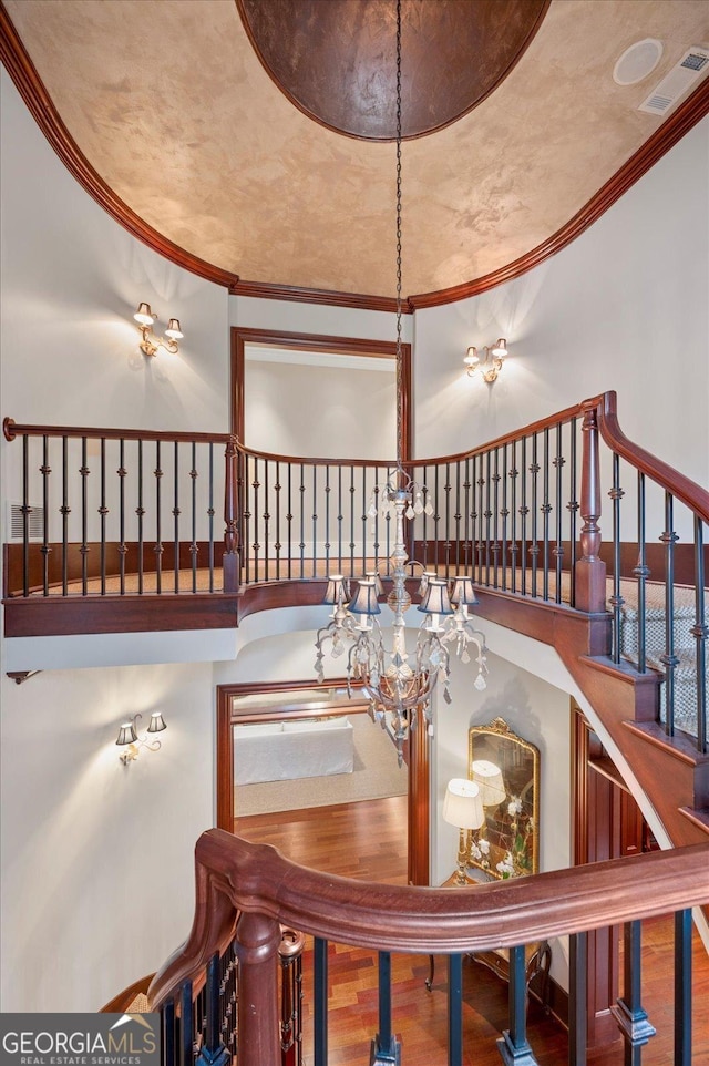 dining space with ornamental molding, a high ceiling, and wood finished floors