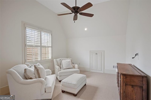 living area with vaulted ceiling, ceiling fan, and carpet flooring
