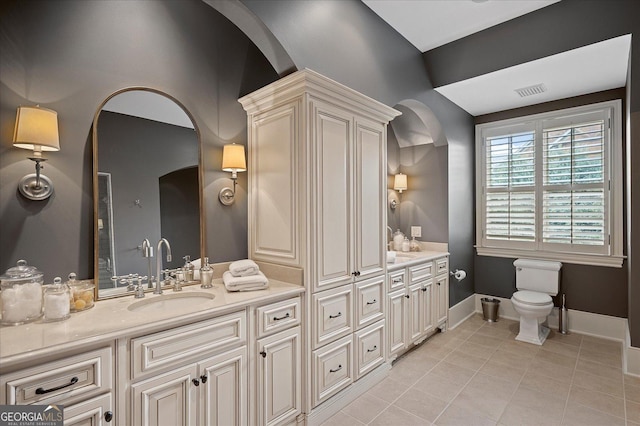 full bath featuring tile patterned flooring, toilet, a sink, baseboards, and double vanity