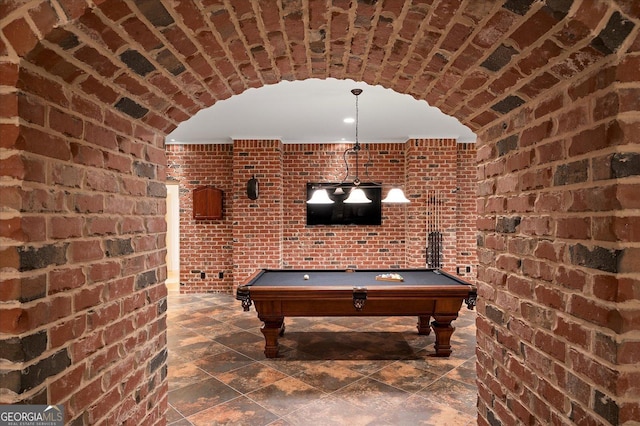 game room with billiards and brick wall