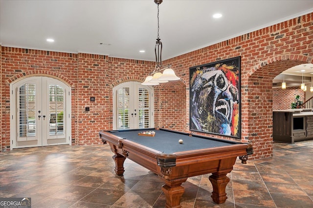 playroom featuring recessed lighting, brick wall, arched walkways, and french doors