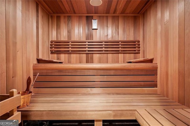 relaxing sauna / steam room with wood walls and wooden ceiling