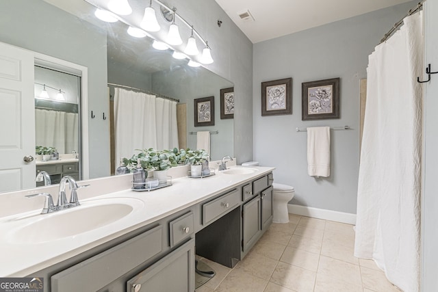 bathroom featuring toilet, visible vents, a sink, and tile patterned floors