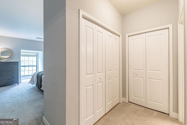 corridor with light colored carpet and baseboards