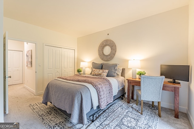 bedroom with a closet, light carpet, and baseboards