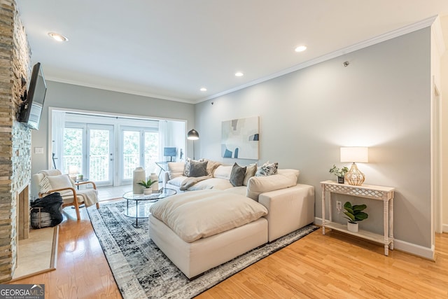 living room featuring light wood-type flooring, baseboards, crown molding, and recessed lighting