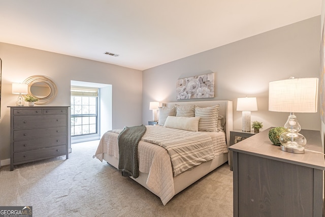 bedroom featuring visible vents and light colored carpet