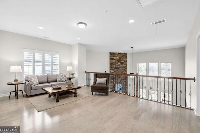 living area featuring recessed lighting, wood finished floors, visible vents, baseboards, and attic access