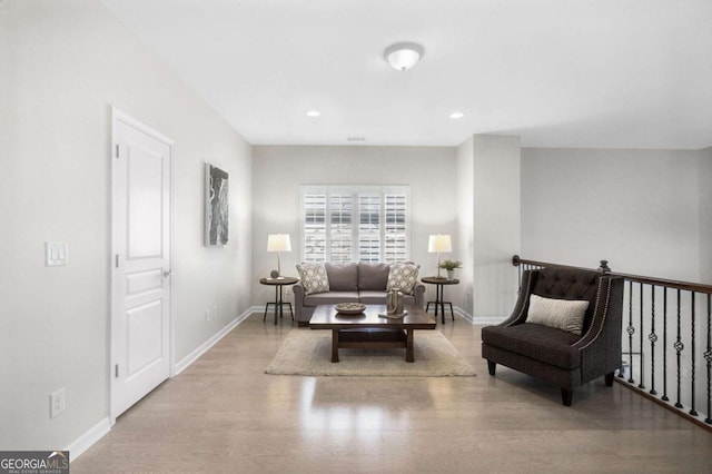 sitting room featuring baseboards, wood finished floors, and recessed lighting