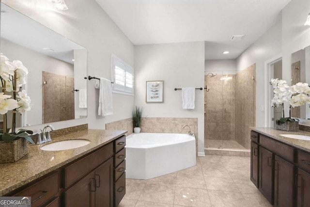 bathroom with a bath, a shower stall, a sink, and tile patterned floors