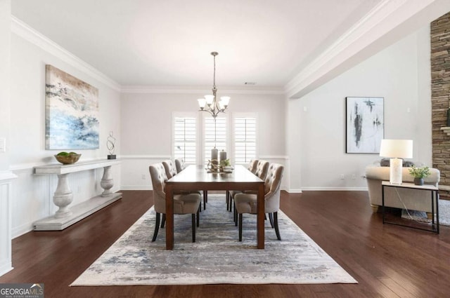 dining area with ornamental molding, a notable chandelier, and dark wood-style floors