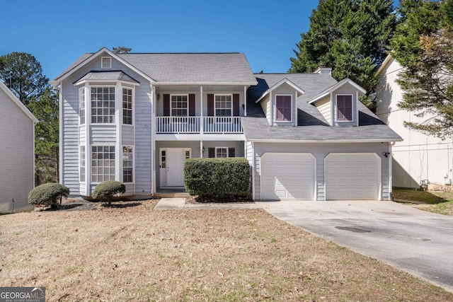 view of front of house featuring concrete driveway, an attached garage, a balcony, and a front yard