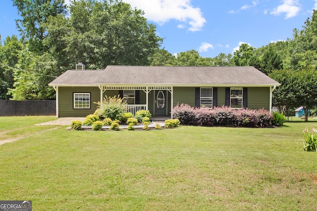 single story home featuring covered porch, fence, and a front lawn