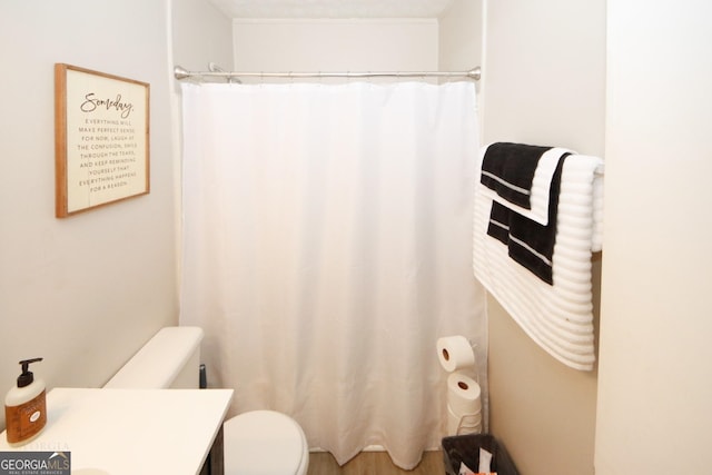 full bath featuring a shower with shower curtain, vanity, and toilet