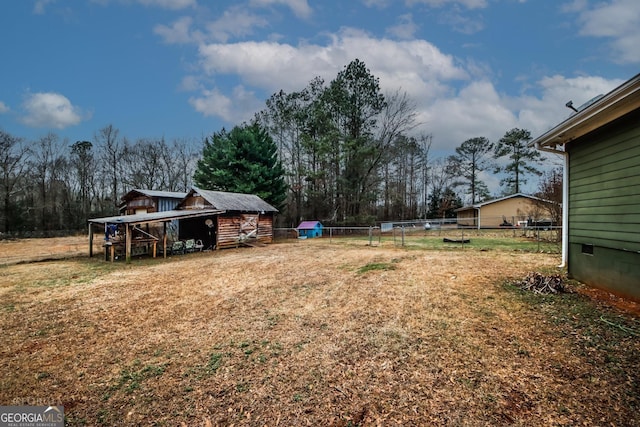 view of yard featuring an outbuilding and fence