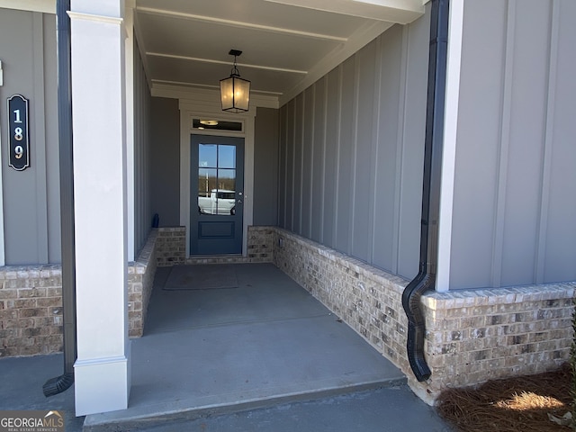 property entrance with brick siding and board and batten siding