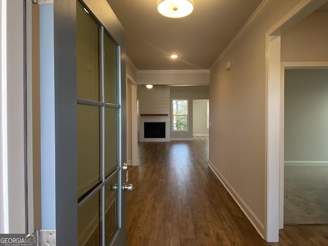 hall featuring ornamental molding, dark wood finished floors, and baseboards