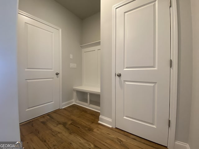 mudroom with dark wood finished floors and baseboards