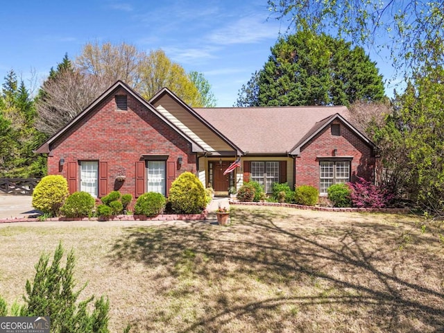 view of front of property featuring brick siding and a front lawn