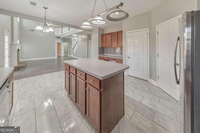 kitchen featuring visible vents, decorative backsplash, freestanding refrigerator, marble finish floor, and light countertops