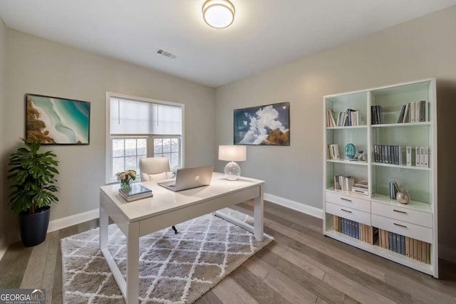 office with wood finished floors, visible vents, and baseboards