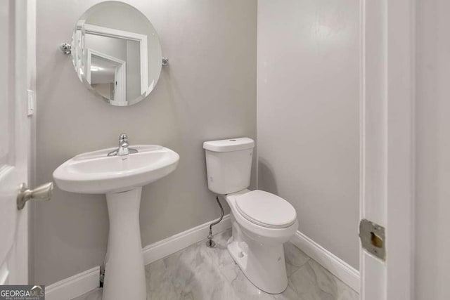 bathroom with toilet and baseboards