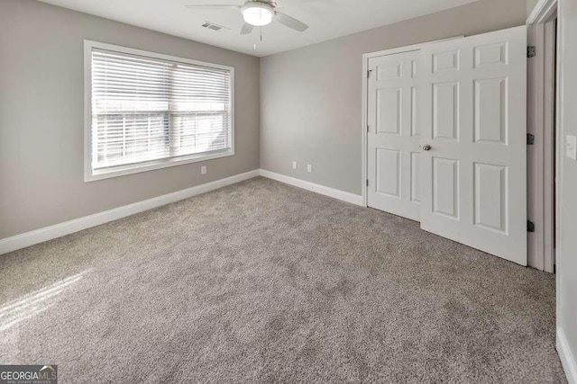 unfurnished bedroom with a ceiling fan, carpet, visible vents, and baseboards