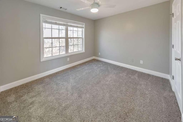 empty room featuring a ceiling fan, visible vents, baseboards, and carpet flooring