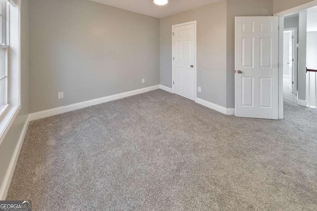 unfurnished bedroom featuring carpet floors and baseboards