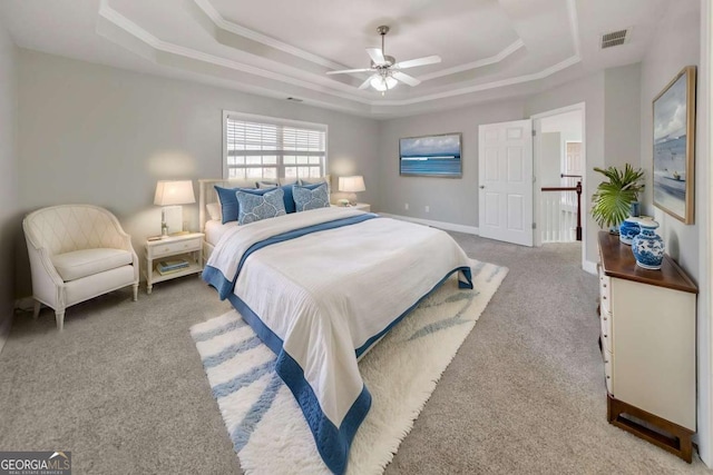 bedroom featuring crown molding, a raised ceiling, visible vents, light carpet, and baseboards